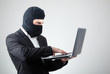 Photo: Portrait of a hacker with balaclava against grey background Portrait of a hacker with balaclava against grey background