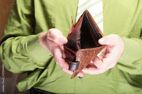 Photo: Empty wallet in male hands - poor economy Empty wallet in male hands - poor economy