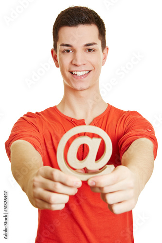 Photo: Mann hält at-Zeichen als Symbol für Internet Mann hält at-Zeichen als Symbol für Internet
