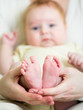 mother hands holding small baby's feet