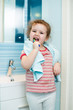 Kid girl brushing teeth in bathroom