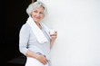grauhaarige Frau nach dem Workout mit einem Glas Milch