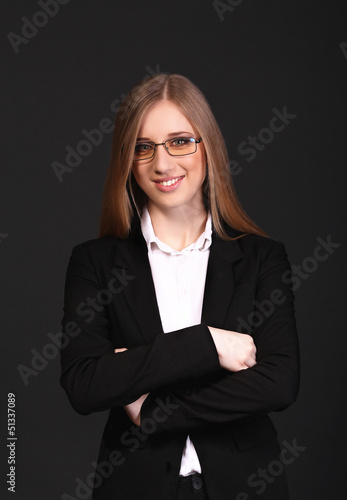 Photo: Beautiful young business woman isolated in black background Beautiful young business woman isolated in black background