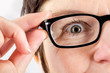 Woman holding glasses to see better