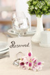 Reserved sign on restaurant table with empty dishes and glasses