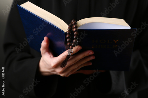 Photo: Priest reading from the holy bible, close up Priest reading from the holy bible, close up