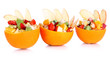 Fruit salad in hollowed-out orange isolated on white