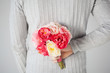 man hiding bouquet of flowers