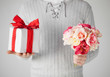 man holding bouquet of flowers and gift box