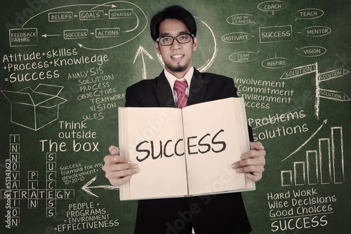 Photo: Businessman holding book of success Businessman holding book of success