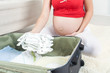 Photo: Pregnant woman packing baby clothes Pregnant woman packing baby clothes