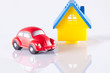 small red toy beetle car and house on white with reflection