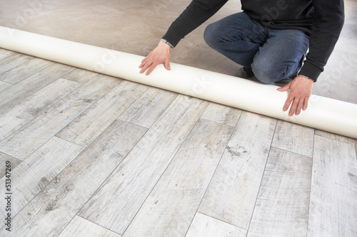 Photo: rolling out a PVC flooring rolling out a PVC flooring