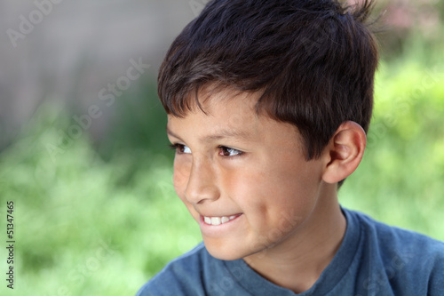 Photo: Smiling young boy outside with copy space to left Smiling young boy outside with copy space to left