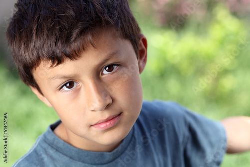 Photo: Serious young boy outside with copy space to right Serious young boy outside with copy space to right