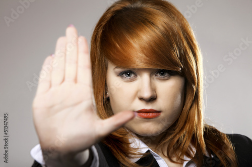 Photo: Young woman making stop gesture sign Young woman making stop gesture sign