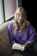 Young Woman with Beautiful Blue Eyes Reading a Book