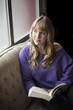 Young Woman with Beautiful Blue Eyes Reading a Book