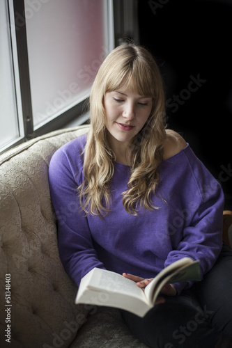 Photo: Young Woman with Beautiful Blue Eyes Reading a Book Young Woman with Beautiful Blue Eyes Reading a Book