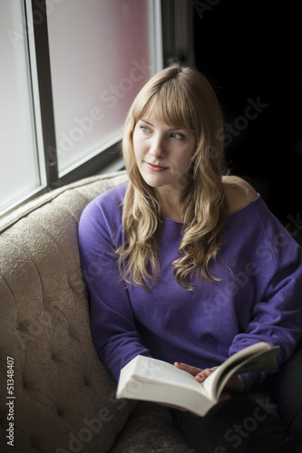 Photo: Young Woman with Beautiful Blue Eyes Reading a Book Young Woman with Beautiful Blue Eyes Reading a Book