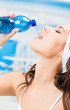 Woman drinking water, at fitness club