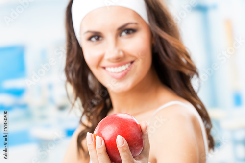 Photo: Woman with apple, at fitness center Woman with apple, at fitness center