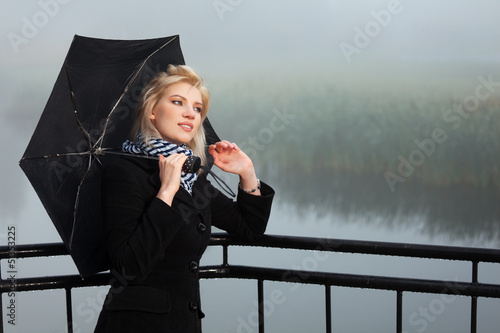 Photo: Young woman against a morning foggy landscape Young woman against a morning foggy landscape