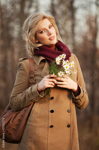 Photo: Young woman with a flowers in autumn forest Young woman with a flowers in autumn forest