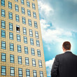 Businessman in front of company building.