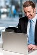 Happy businessman working on laptop