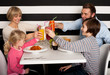 Family toasting smoothies in restaurant