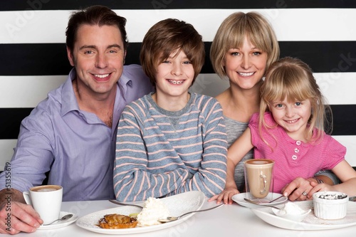 Photo: Family of four having great time in restaurant Family of four having great time in restaurant