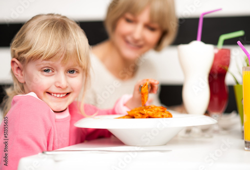 Photo: Cute kid enjoying pasta and juice Cute kid enjoying pasta and juice