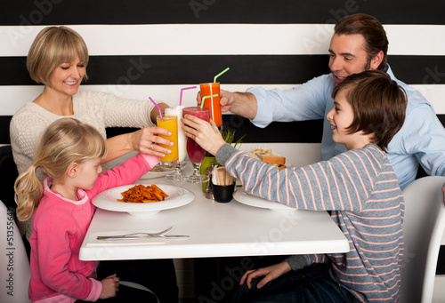 Photo: Family toasting smoothies in restaurant Family toasting smoothies in restaurant