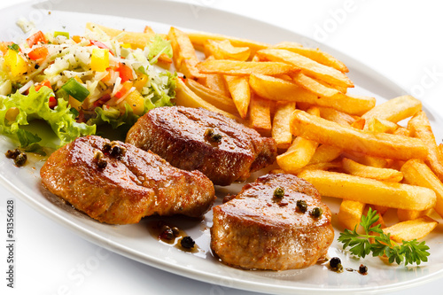Photo: Grilled steaks, French fries and vegetables Grilled steaks, French fries and vegetables