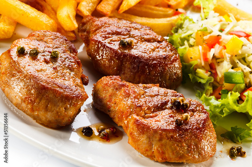 Photo: Grilled steaks, French fries and vegetables Grilled steaks, French fries and vegetables