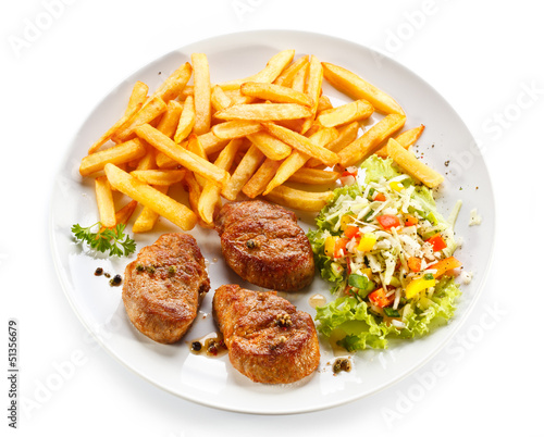 Photo: Grilled steaks, French fries and vegetables Grilled steaks, French fries and vegetables