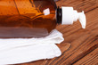 Liquid soap dispenser and a white towel on the oak table