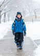 Hispanic Child Walking in the Sidewalk on a Snowy Day