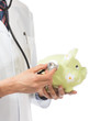 Female Doctor Holding Stethoscope to Pink Piggy Bank