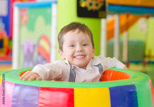 Photo: Happy little boy playing in playroom Happy little boy playing in playroom