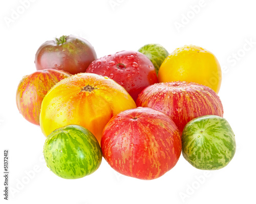 Photo: Heirloom tomatoes with water drops on white background Heirloom tomatoes with water drops on white background