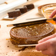 Hands of cook in action spreading cake