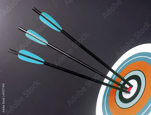 Photo: Three Blue Black Archery Arrows Hit Round Target Bullseye Center Three Blue Black Archery Arrows Hit Round Target Bullseye Center
