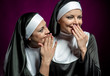 Young attractive nun whispering a secret to another nun