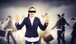 Businesswoman in blindfold among group of people
