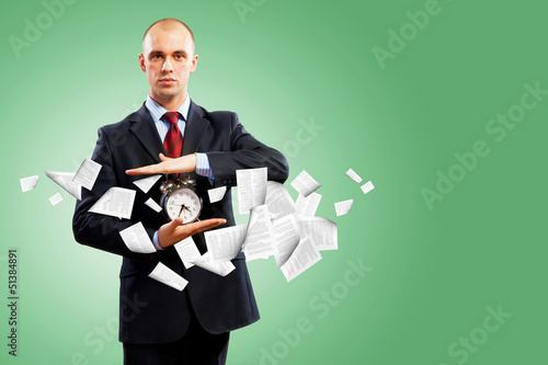 Photo: Business man holding alarmclock Business man holding alarmclock