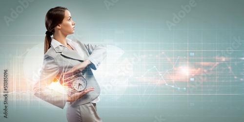Photo: Business woman holding alarmclock Business woman holding alarmclock