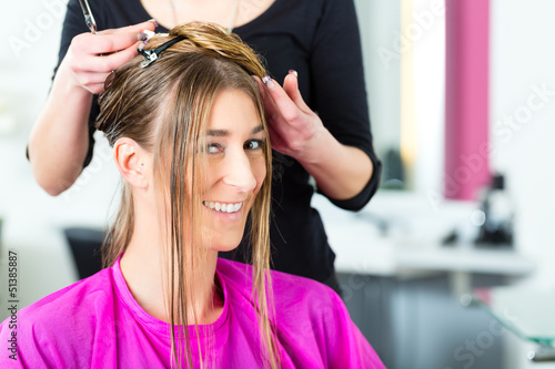 Photo: Woman receiving haircut from hair stylist or hairdresser Woman receiving haircut from hair stylist or hairdresser