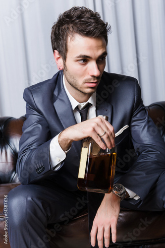 Photo: Worried Young Businessman with Drinking Problems Worried Young Businessman with Drinking Problems